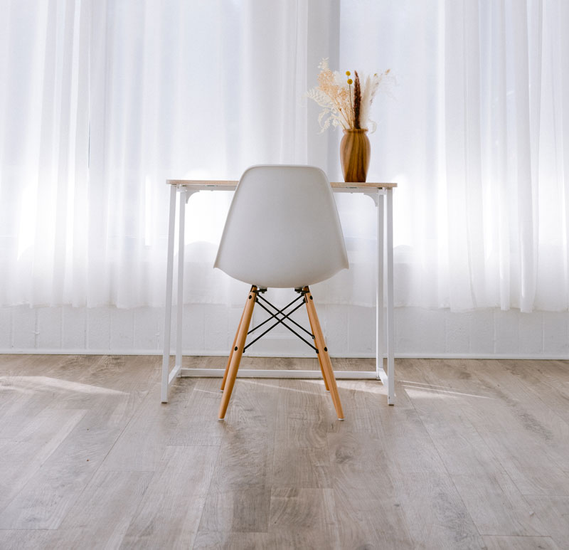 A chair and matching table positioned on a glossy laminated floor.