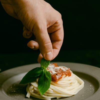 "Spaghetti with mince and basil garnish on a plate.