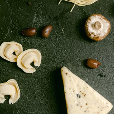 Cheese, olives and mushrooms on a surface
