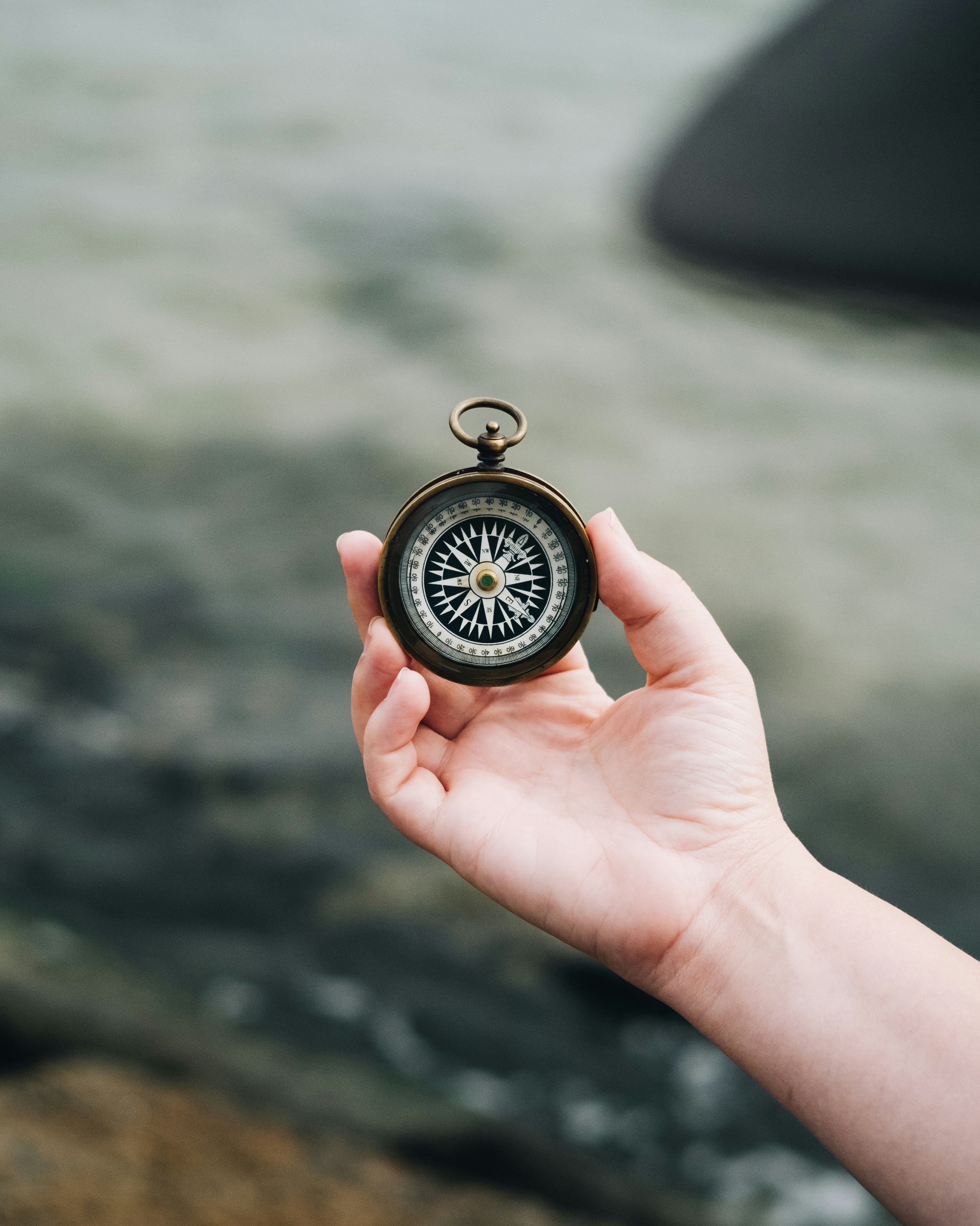White hand holding a compass